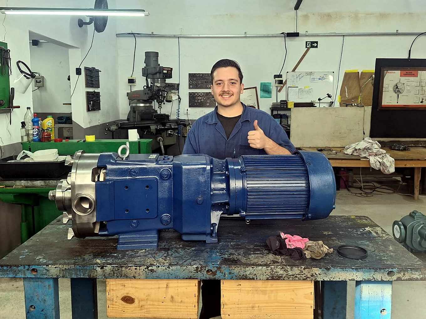 Técnico da FMC na oficina, atrás de uma bomba montada sobre a bancada